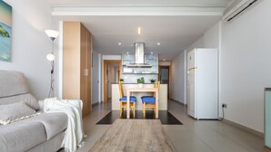 Un salon moderne comprenant un canapé, une table basse et un coin repas avec des chaises et une table.