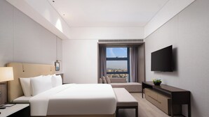 A modern hotel room with a large bed, bedside table, desk, and a TV mounted on the wall. - EDDRER HOTEL (Shenzhen)