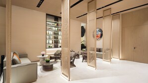 A modern interior with a sofa, chairs, a coffee table, and a bookshelf. - EDDRER HOTEL (Shenzhen)