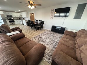 Relax in this stylish living room with a sofa, dining table, and flat-screen TV.