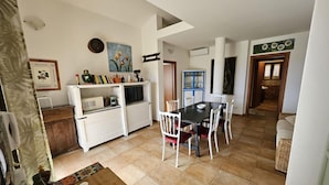 A compact kitchen with a dining area, white cabinets, a microwave, and a dining table with chairs. - House for 12 with Pool (Masone Pardu)