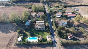 An aerial view of a residential area with houses, a swimming pool, and solar panels. - House for 12 with Pool (Masone Pardu)