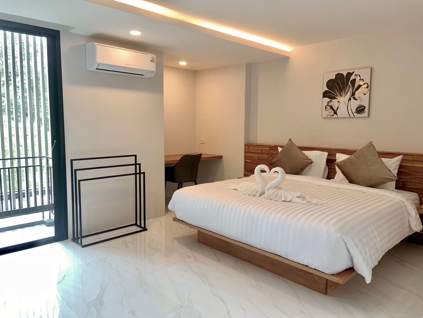Une chambre d’hôtel moderne dotée d’un grand lit, d’un bureau et d’un balcon.