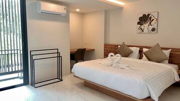 Une chambre d’hôtel moderne dotée d’un grand lit, d’un bureau et d’un balcon.