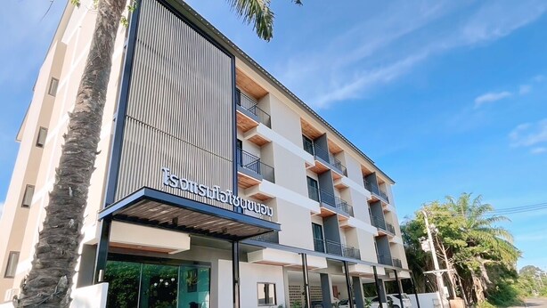 A multi-story hotel with a modern design, featuring balconies on each floor and a visible entrance with a covered area. - Ozone hotel khhanom (Khanom)