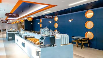 Un moderno comedor para el desayuno con barra libre, que incluye una cafetera y diferentes opciones de comida.