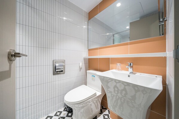 Une salle de bain avec des toilettes, un lavabo et un miroir.