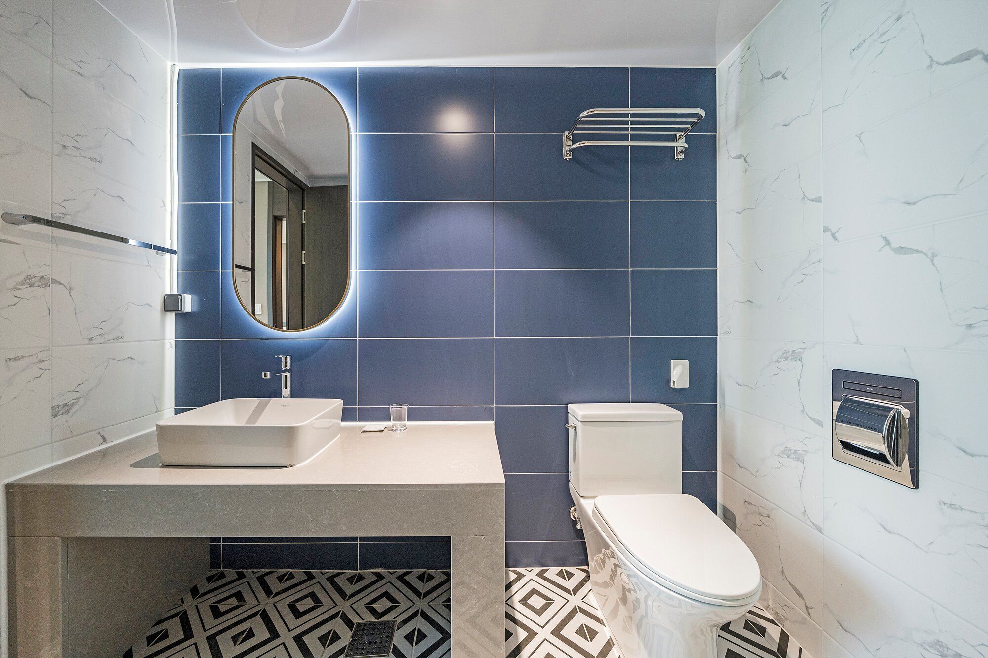 A bathroom with a white sink, a toilet, and a mirror.