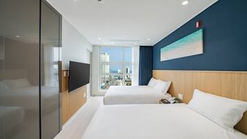A hotel room with two beds, a TV, a city view, and a painting on the wall.