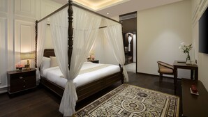 A four-poster canopy bed with a nightstand, a bedside table with a lamp, and a decorative rug. - The Fort House, Diu- IHCL SeleQtions (Diu)