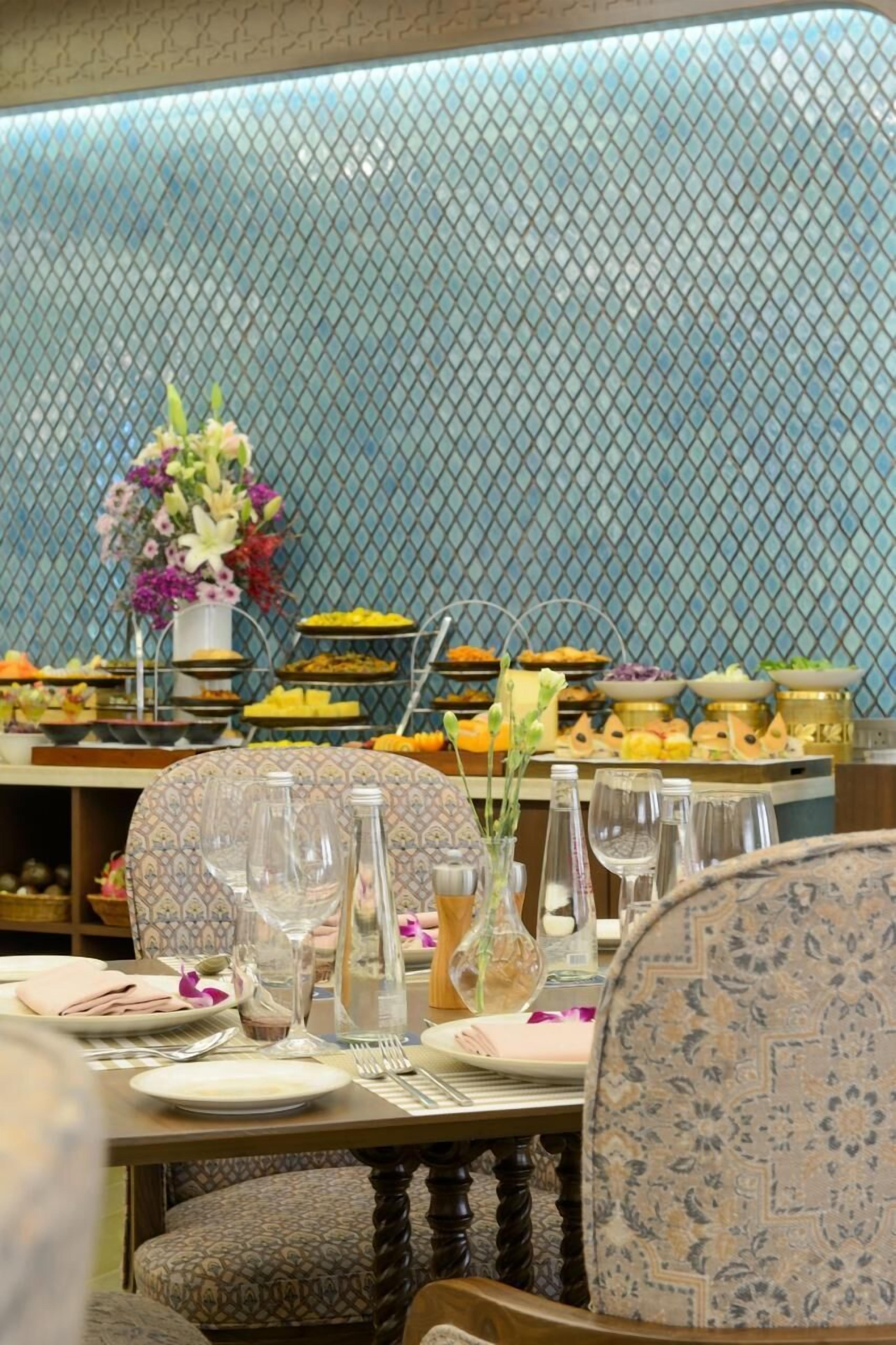 Ein Essbereich mit einer Buffet-Anrichtung, darunter verschiedene Speisen und eine Blumendekoration.