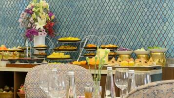 Ein Essbereich mit einer Buffet-Anrichtung, darunter verschiedene Speisen und eine Blumendekoration.