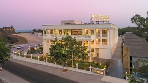 A two-story hotel with a balcony, a sign reading "The Fort House," and a view of the road and beach. - The Fort House, Diu- IHCL SeleQtions (Diu)