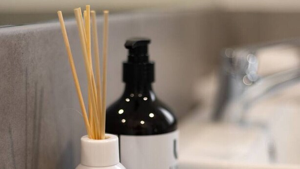 Ein Badezimmer-Waschtisch mit einer weißen Flasche mit dem Aufdruck 'vanilla cream' und einer schwarzen Flasche mit Pumpspender.