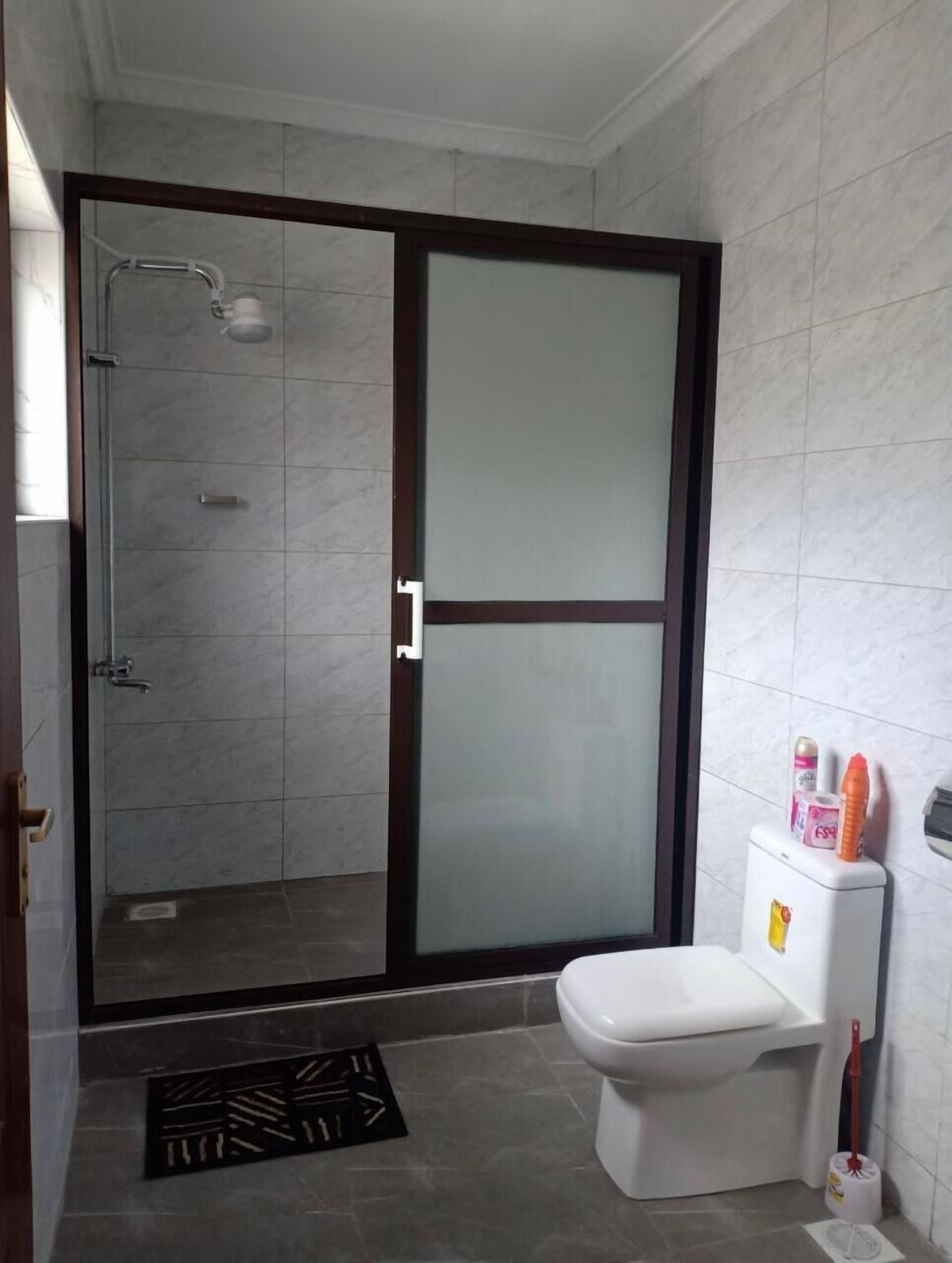 A bathroom with a glass-enclosed shower, a toilet, and a bidet.
