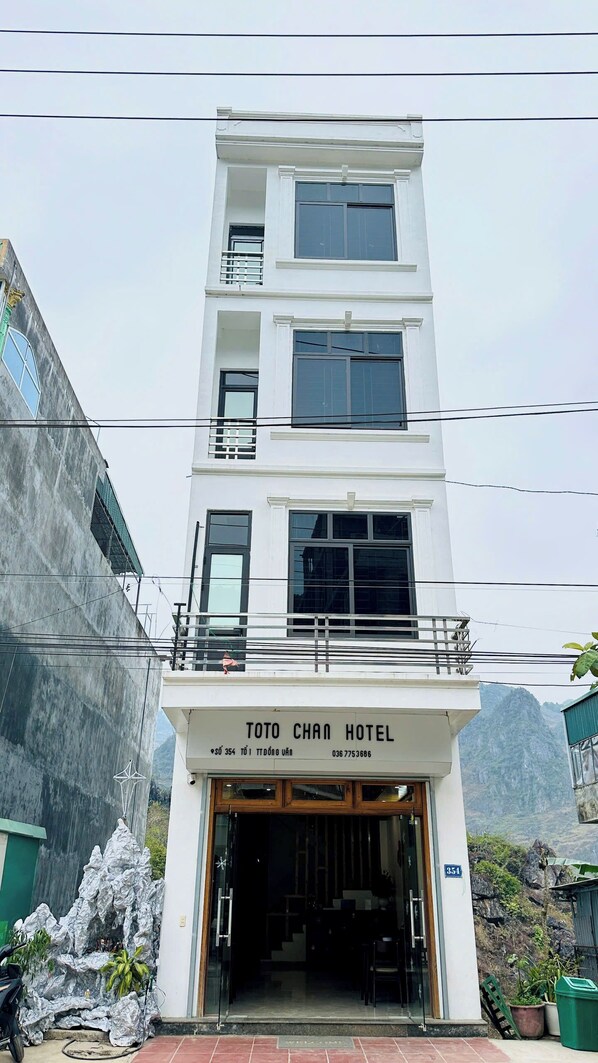 A multi-story hotel with a sign reading "TOTO CHAN HOTEL" at the entrance.