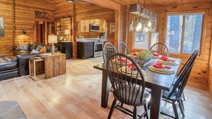Un intérieur chaleureux de chalet en bois, comprenant un coin repas, une cuisine et un salon.