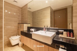 A modern bathroom with a large sink, mirror, and wooden cabinets. - 1BR Apt Urban Oasis near Dubai Mall (Dubai)