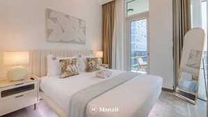 A hotel room with a large bed, a bedside table with a lamp, a mirror, and a window with curtains. - 1BR Apt Urban Oasis near Dubai Mall (Dubai)