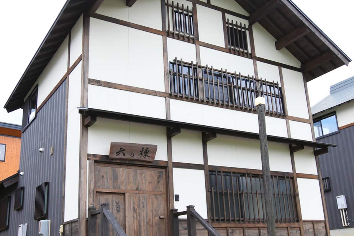 A multi-story building with a wooden door and a sign with Japanese characters.