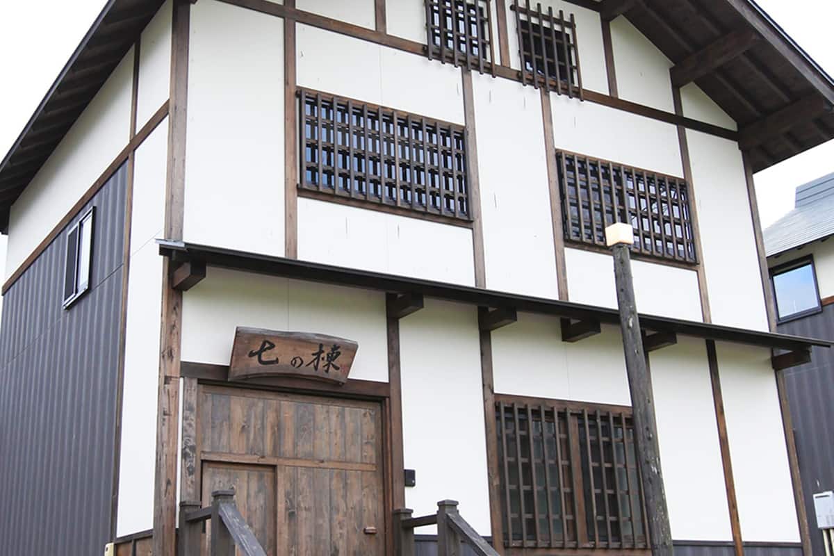 A traditional Japanese building with a wooden door and a sign.