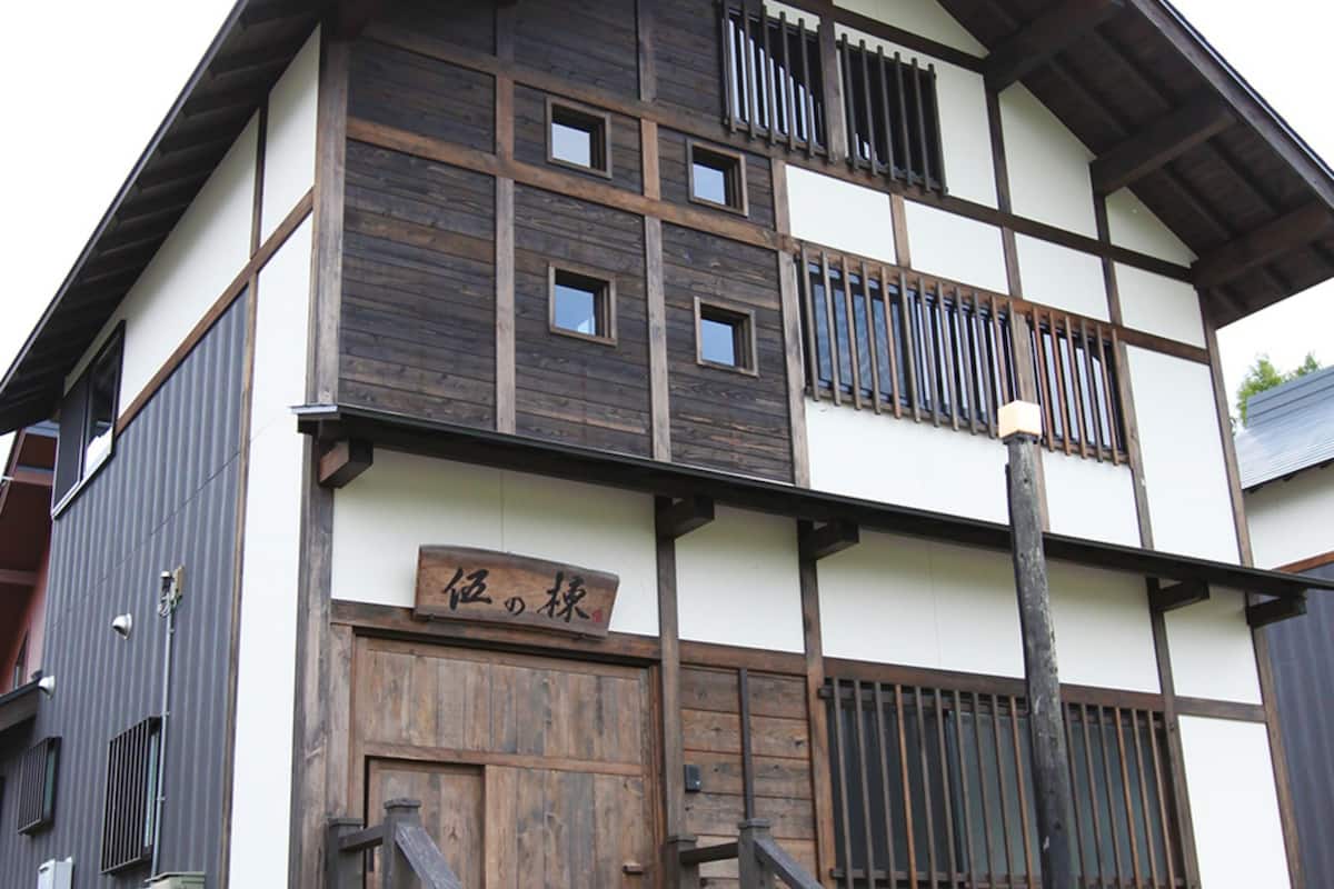 A multi-story building with a traditional architectural style, featuring wooden beams and a large wooden door.