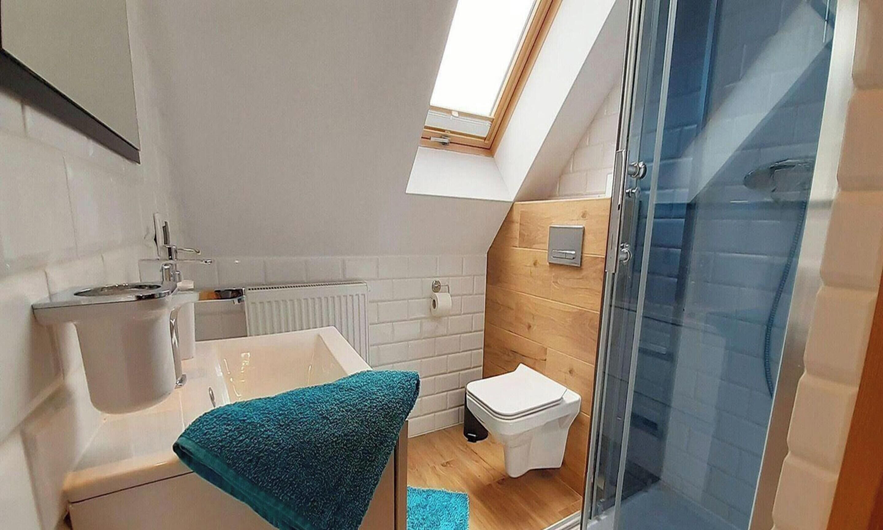 Une salle de bain moderne équipée d’une douche, de toilettes et d’un lavabo.