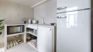 A compact kitchen with a white refrigerator, a microwave, and a sink. - Beautiful AC Duplex Bastille Le Marais (Paris)