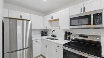 Fully Equipped Kitchen in Unit 2. From morning coffee to full meals, this modern kitchen has it all. Stainless steel appliances, cookware, utensils, and plenty of counter space.