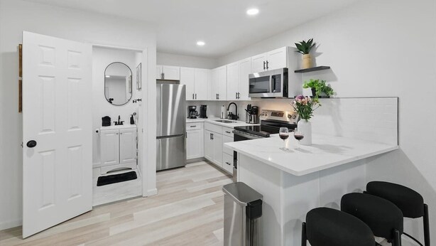 A modern kitchen with white cabinetry, stainless steel appliances, and a white countertop. - Modern 2BR 3rd Unit (Haltom City)