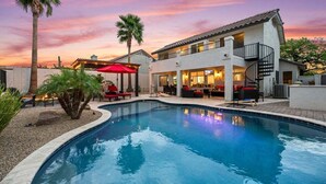 A two-story house with a swimming pool, outdoor seating, and a sunset view. - Par-Fect Views | Red Mountain Golf Course, Heated Pool , Incredible Red Mountain Views (Mesa)