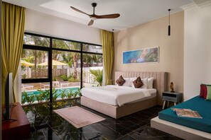 Una habitación de hotel con un ventanal grande, una cama, un escritorio y una mesita.