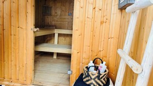 A wooden sauna room with benches and a woven basket containing toiletries. - Your home in the Bavarian Alps - Spacious vacation on 90 m² with wellness (Flintsbach am Inn)