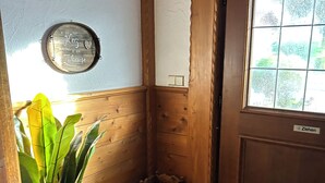 A wooden interior with a door labeled "Ziehen," a small trash bin, and a potted plant. - Your home in the Bavarian Alps - Spacious vacation on 90 m² with wellness (Flintsbach am Inn)