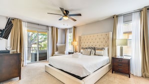 A spacious bedroom with a large bed, a ceiling fan, a nightstand, and a view through the glass door. - 9 Mi to WDW: Townhouse w/ Balcony in Davenport! (Davenport)