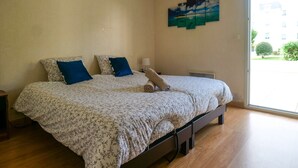A bedroom with a bed, two pillows, a lamp, and a painting on the wall.