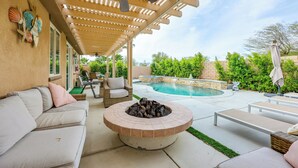 A covered outdoor patio with a fire pit, lounge chairs, and a pool. - Gazebo + Putting Green: Serene Indio Getaway (Indio)