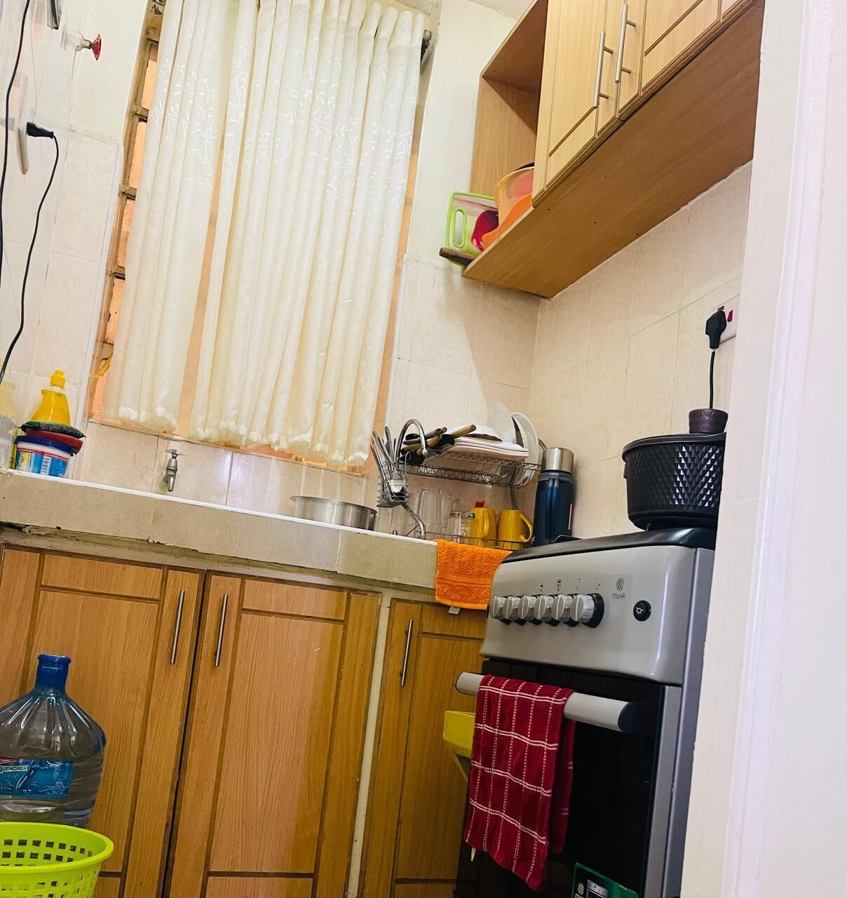 A kitchen with wooden cabinets, a stainless steel sink, and a stove.