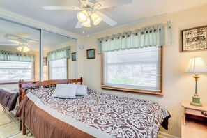 A bedroom with a large bed, a ceiling fan, a window with blinds, a bedside lamp, and a mirror. - 2 Mi to Venice Beach: Home w/ Pool Access (Venice)