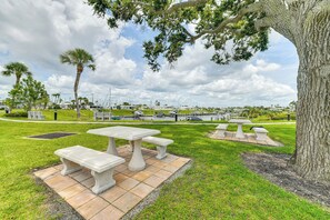 A picnic area with tables and benches, surrounded by grass and trees, with a marina and boats in the background. - 2 Mi to Venice Beach: Home w/ Pool Access (Venice)
