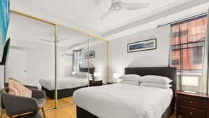 Een moderne hotelkamer met een groot bed, een stoel, een bureau en een spiegel.