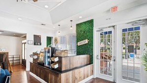 A bakery counter with a wooden finish, a green wall with a 'BAKERY' sign, and a glass door leading outside. - Welcoming 4 BR Sleeps 10 Guests (Kissimmee)
