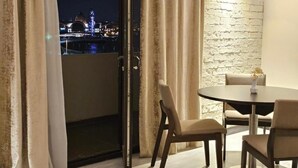 A room with a balcony, a round table, and chairs. - Crown Suites Hotel (Baku)
