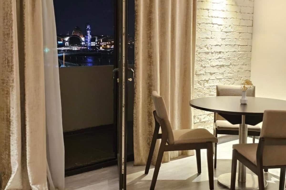A room with a balcony, a round table, and chairs.