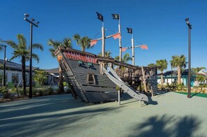 Un parque infantil de temática pirata con toboganes y estructuras para escalar.