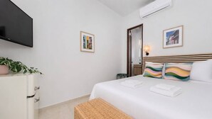A hotel room with a bed, a TV, a dresser, and a mirror. - Room 14: Chill City Veranda Near Miramar (San Juan)