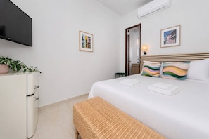 A hotel room with a bed, a TV, a dresser, and a mirror. - Room 14: Chill City Veranda Near Miramar (San Juan)