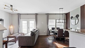 Ein modernes Wohnzimmer mit einer Couch, Essbereich und Küche.