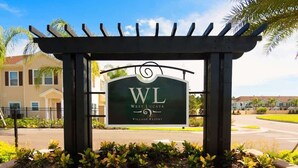 A sign for West Lucaya Village Resort with a pergola structure.