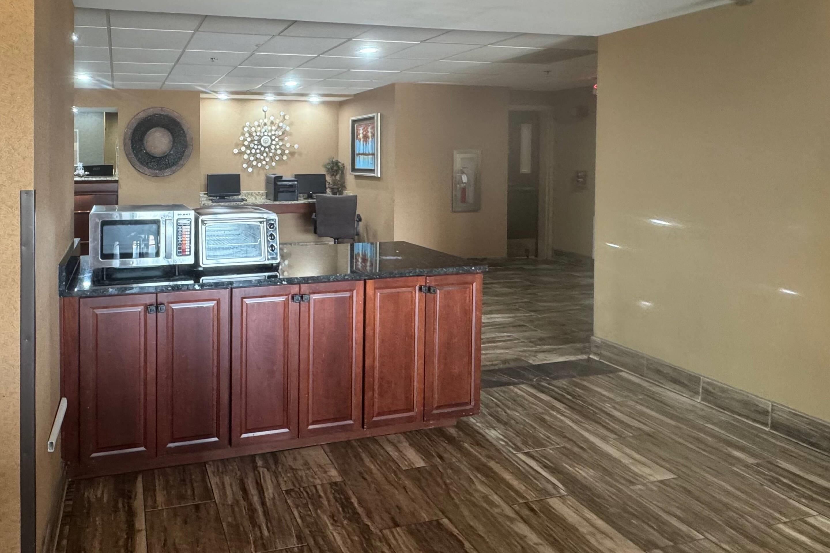 A kitchen with a wooden cabinet, a microwave, and a toaster.